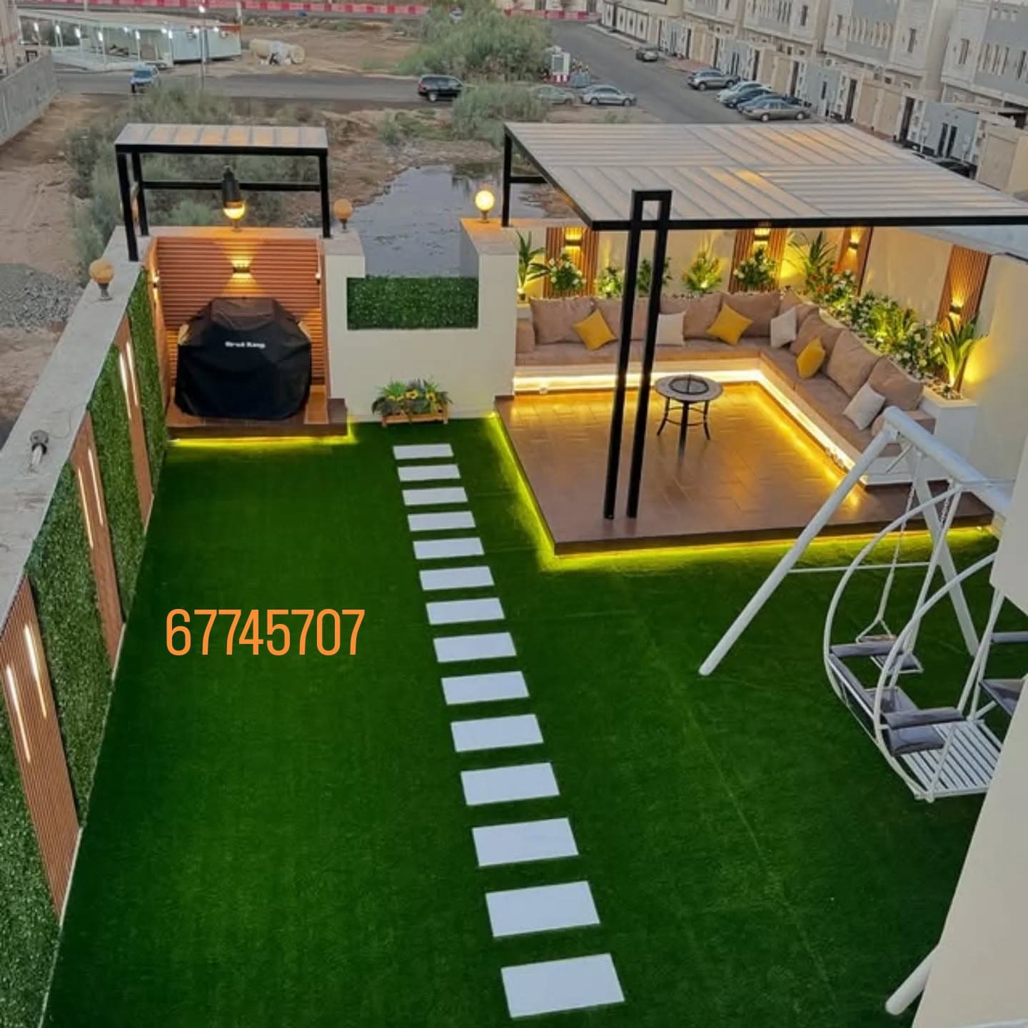 "حديقة على السطح تضم مظلة وثيل صناعي وجلسة خارجية مع ديكور بديل الخشب."