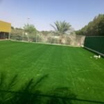 "فني يقوم بتثبيت الثيل الصناعي مع تجهيز الأرضية"